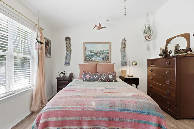 a bedroom with a bed and a mirror on the dresser