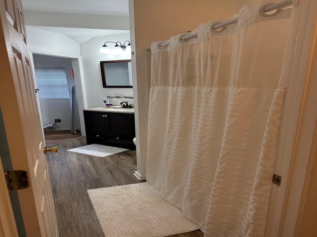 4347 Travis Street, Unit 4347 Dallas, TX 75205 - Photo 8 of 12 a bathroom with a sink a mirror and a shower curtain