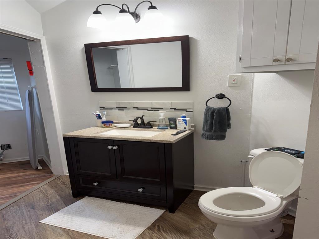 4347 Travis Street, Unit 4347 Dallas, TX 75205 - Photo 9 of 12 a bathroom with a toilet a sink and mirror