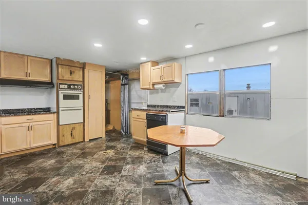 a kitchen with a refrigerator a oven and white cabinets
