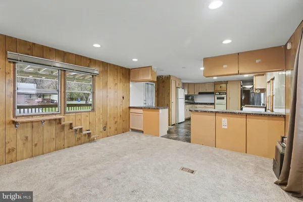a kitchen with stainless steel appliances kitchen island granite countertop a refrigerator oven stove a sink with island and chairs