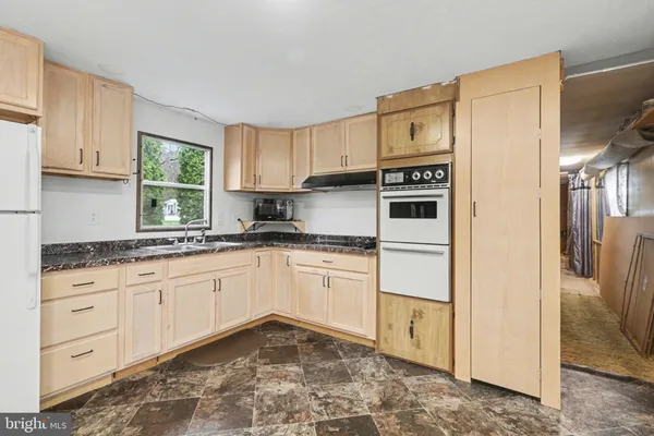 a kitchen with granite countertop white cabinets and stainless steel appliances