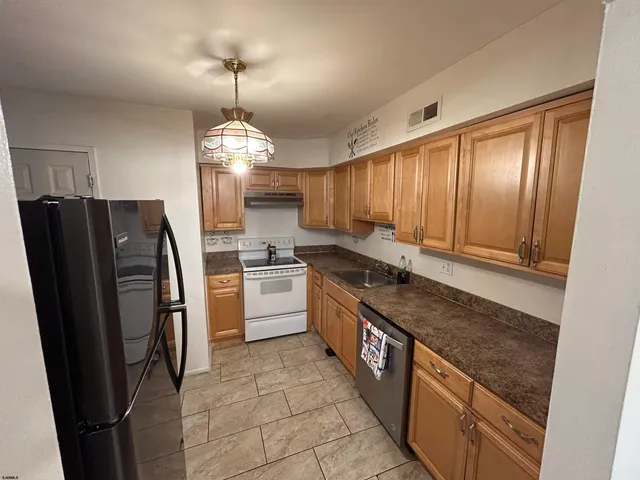 a kitchen with stainless steel appliances granite countertop a stove refrigerator and cabinets
