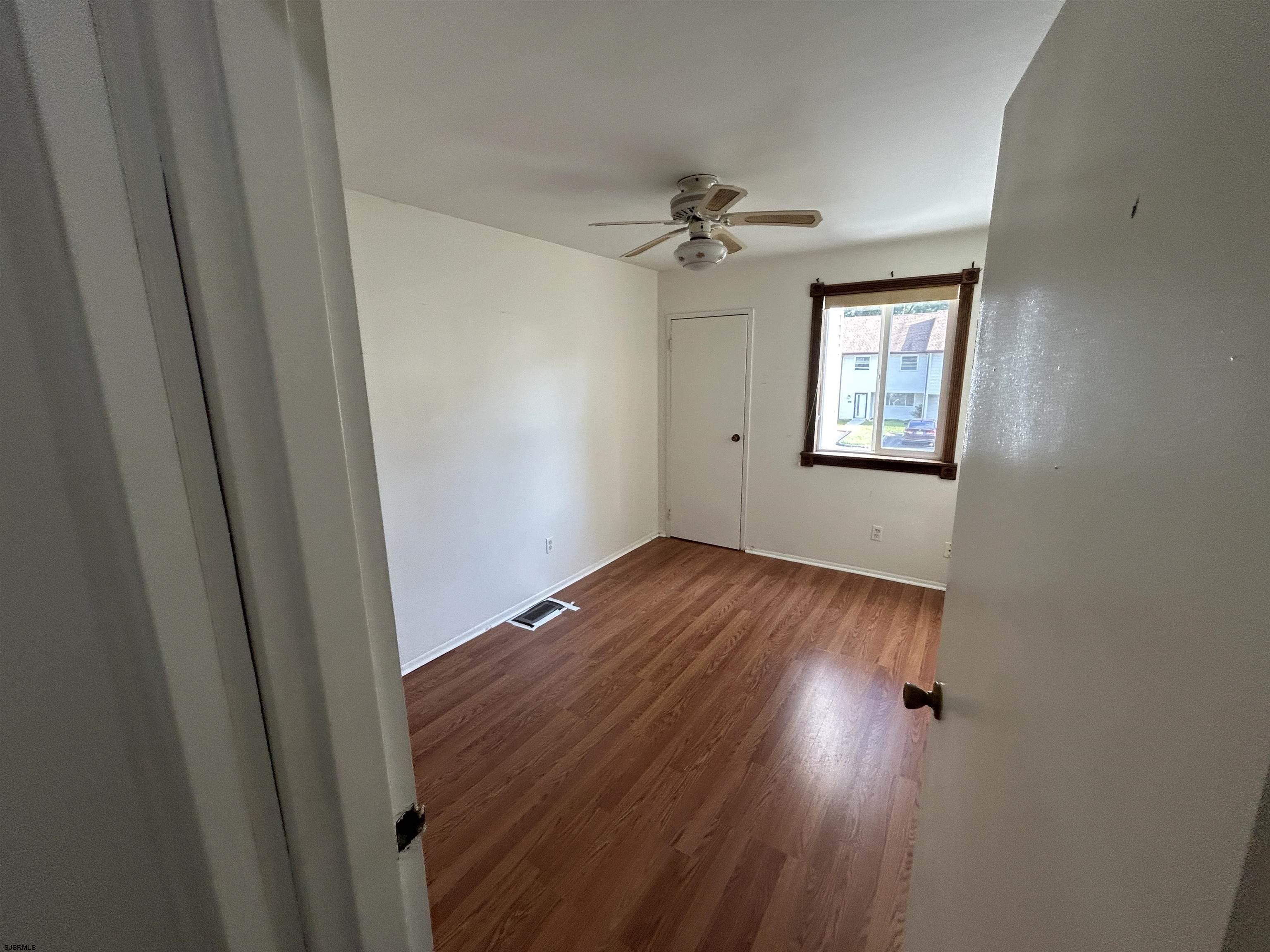2465 Arbor Court, Unit 2465 Mays Landing, NJ 08330 - Photo 6 of 10 a view of empty room with wooden floor and fan