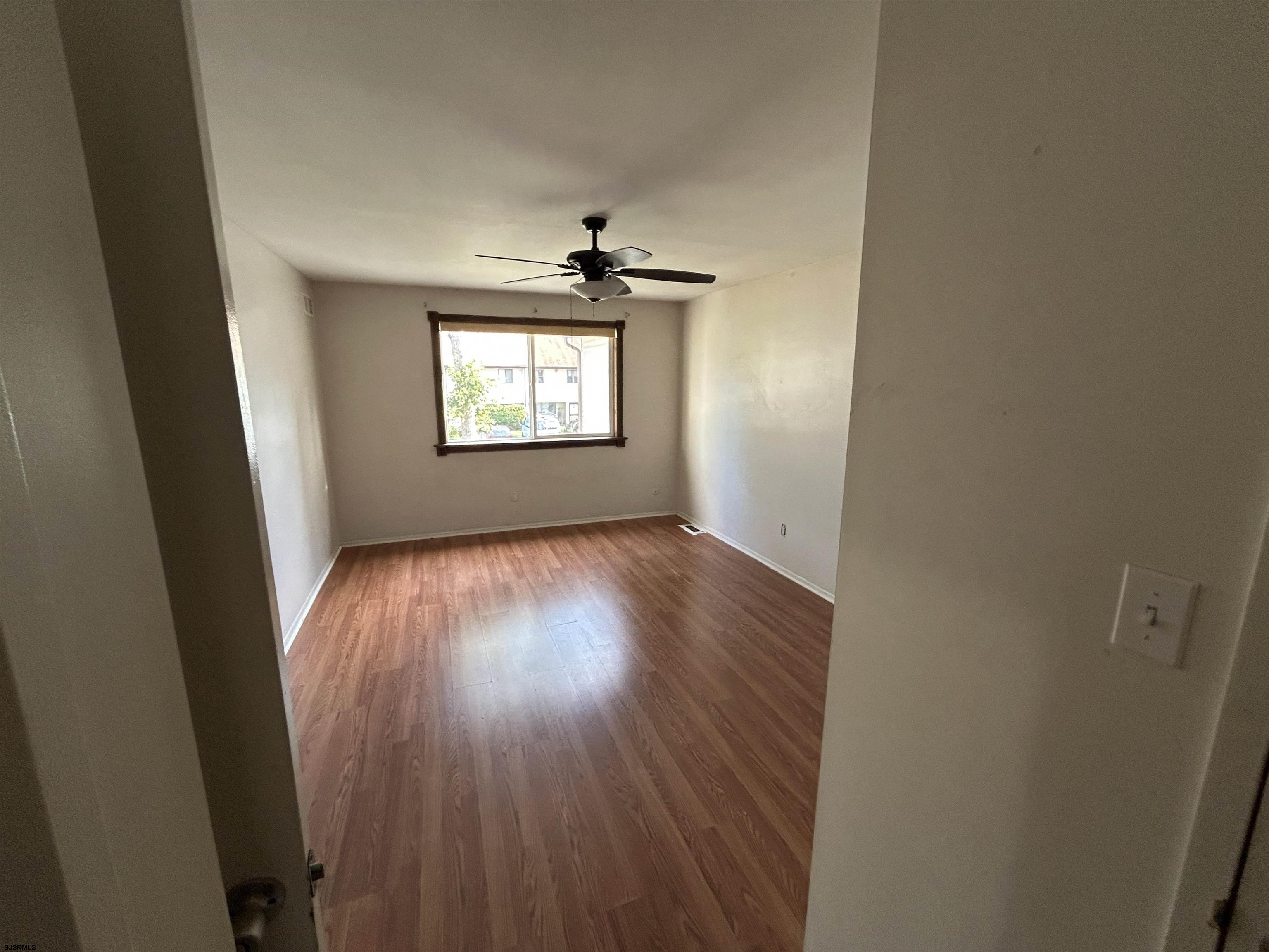 2465 Arbor Court, Unit 2465 Mays Landing, NJ 08330 - Photo 10 of 10 an empty room with wooden floor and windows