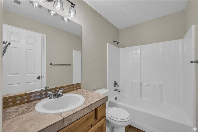 3155 South Hidden Dr Street, Unit 248 St. George, UT 84790 - Photo 11 of 24 Bathroom featuring a built-in vanity with a tiled countertop and integrated sink, a large wall-mounted mirror, and a full-size tub with shower