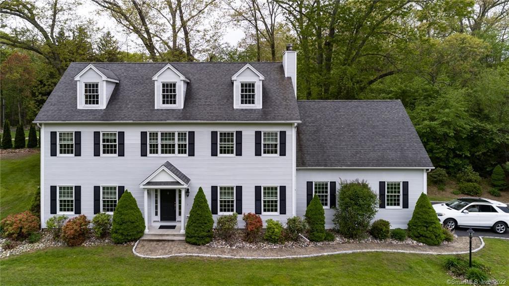 a front view of a house with yard and green space