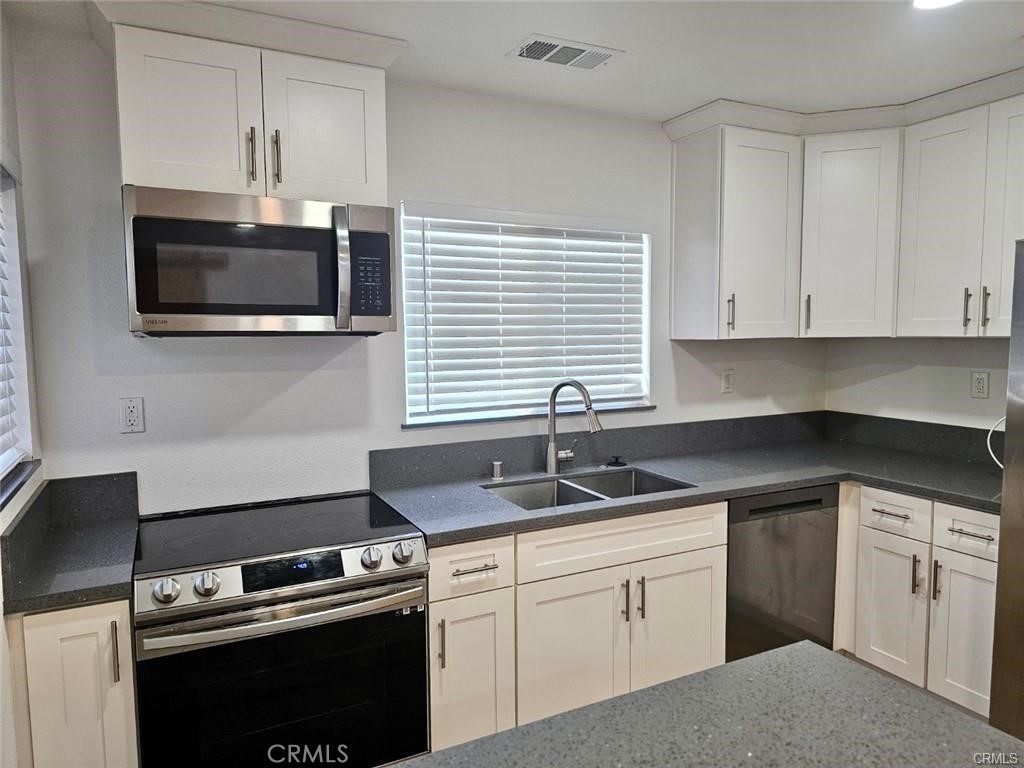 769 East 7th Street, Unit B Upland, CA 91786 - Photo 6 of 12 a kitchen with granite countertop cabinets stainless steel appliances and a sink