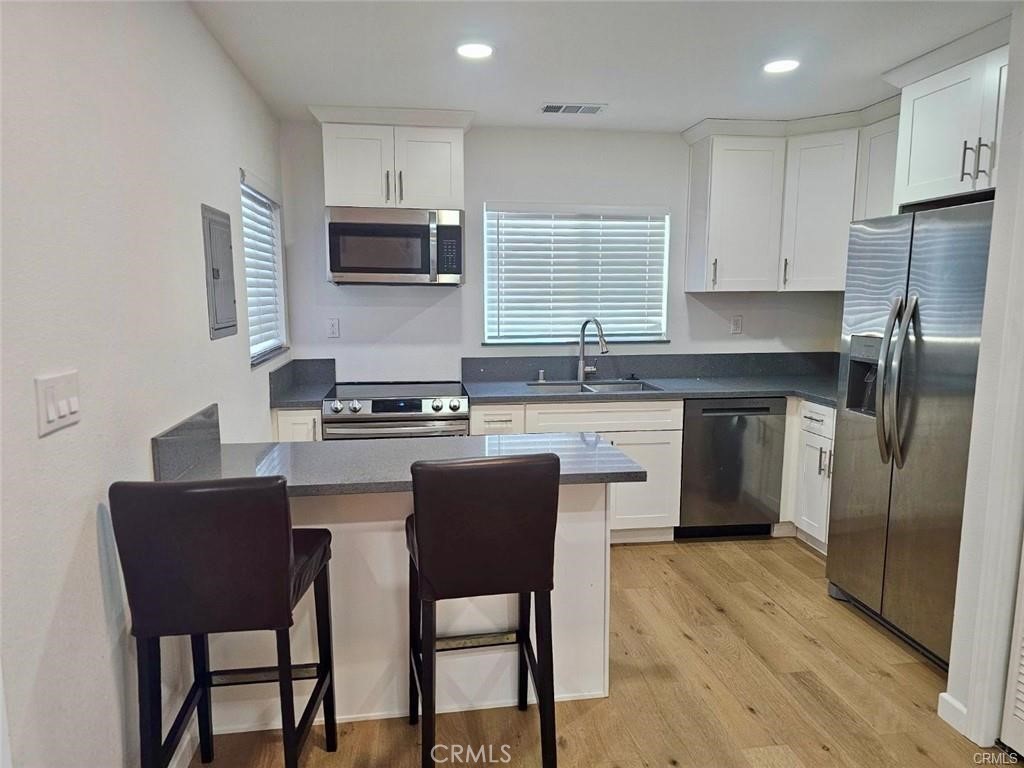 769 East 7th Street, Unit B Upland, CA 91786 - Photo 7 of 12 a kitchen with stainless steel appliances granite countertop a stove a sink a microwave a refrigerator and chairs
