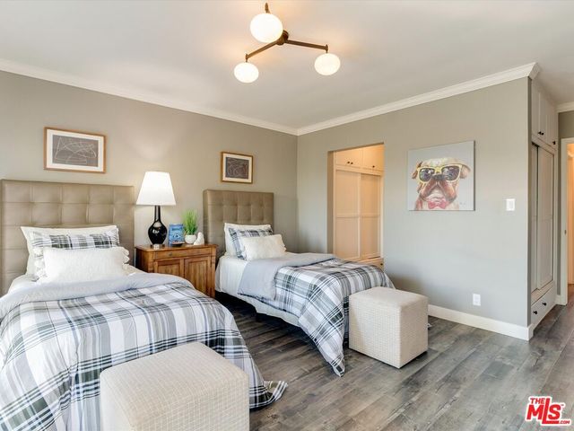 a bedroom with two beds and painting on the wall