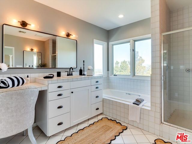 a bathroom with a double vanity sink mirror and bathtub