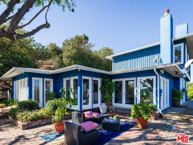 a front view of a house with porch and garden