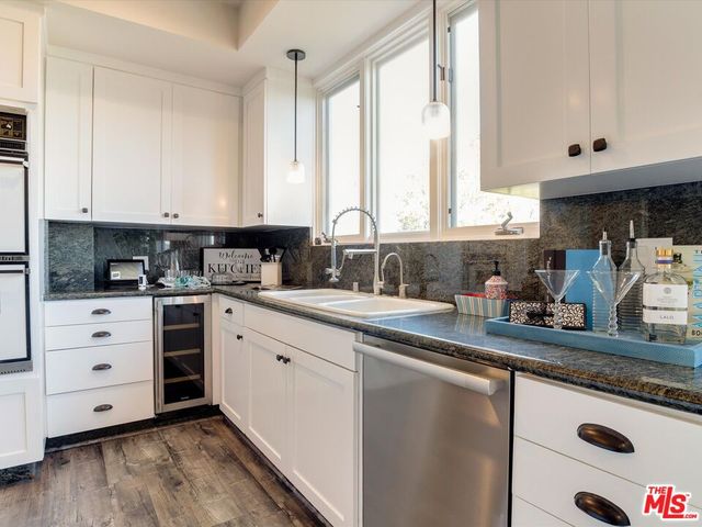 a kitchen with granite countertop white cabinets and white appliances
