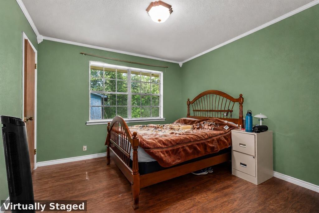3216 Old Ewing Road Lufkin, TX 75901 - Photo 20 of 24 Bedroom featuring wood-finish flooring, a double-paned window, painted walls, and a ceiling-mounted light fixture