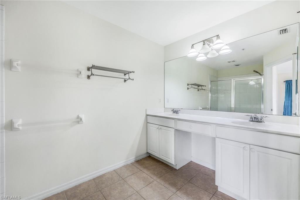 15612 Marcello Circle, Unit 158 Naples, FL 34110 - Photo 13 of 27 a spacious bathroom with a granite countertop sink mirror and a shower