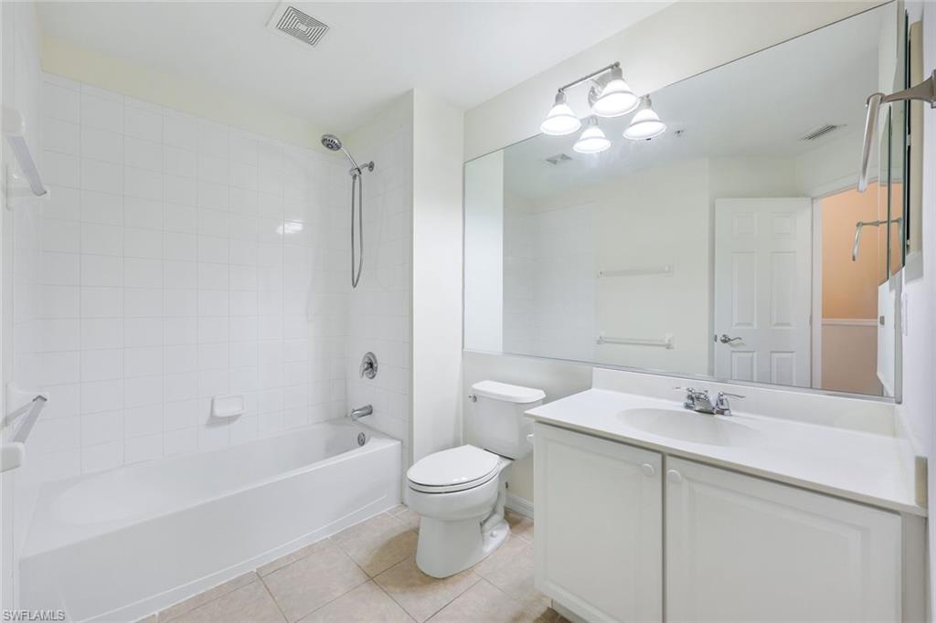 15612 Marcello Circle, Unit 158 Naples, FL 34110 - Photo 15 of 27 a bathroom with a sink a toilet and a large mirror