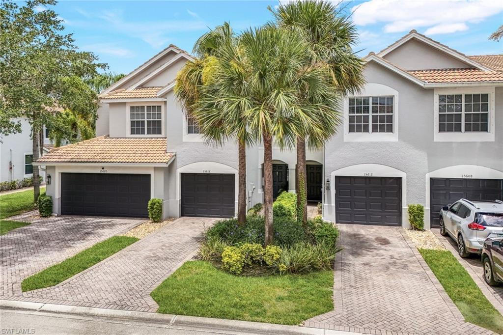 15612 Marcello Circle, Unit 158 Naples, FL 34110 - Photo 23 of 27 a front view of a house with a garden and trees