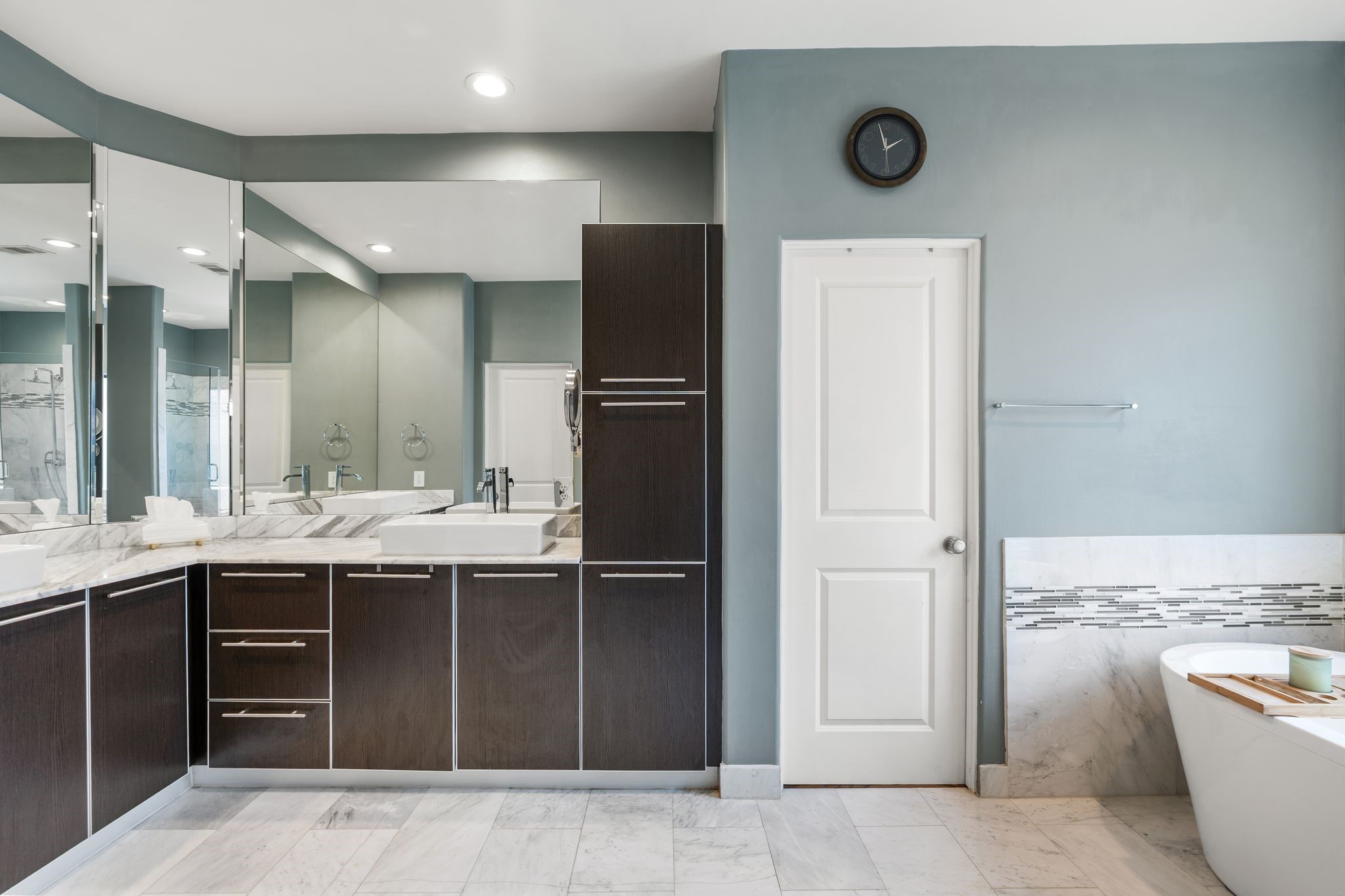 3934 Feagan Street Houston, TX 77007 - Photo 16 of 27 Marble flooring runs throughout the bathroom and the layout allows for plenty of counter space and storage without feeling tight. It's a clean modern setup that's easy to use day to day. The door ahead leads to one of two large walk in closets. This space also has a private water closet.