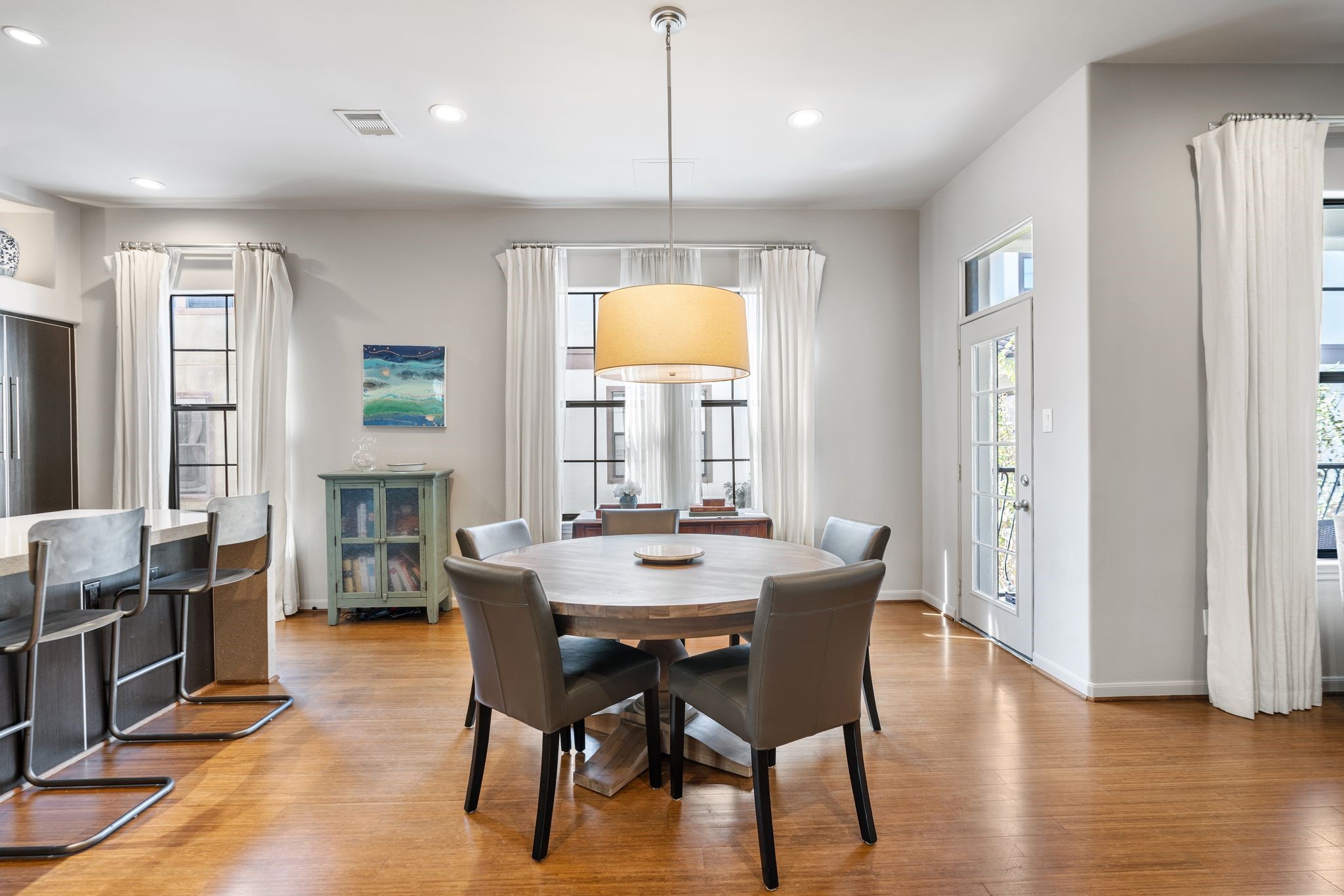 3934 Feagan Street Houston, TX 77007 - Photo 8 of 27 The dining area feels open with plenty of space for a full size table, making it easy to host weeknight dinners. Tall windows dressed with drapes bring in soft natural light and the statement pinned it adds a warm, modern touch. The setup is ideal for anyone who wants a dedicated dining space without sacrificing flow.