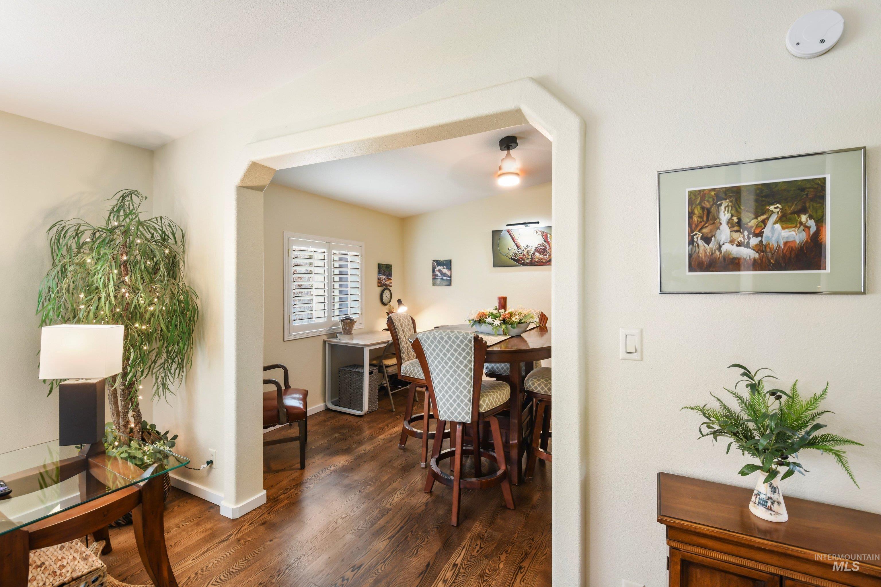 421 South Curtis Road, Unit 202 202 Boise, ID 83705 - Photo 10 of 41 Living area featuring wood-finish flooring, a built-in entertainment center with lower cabinetry, plantation shutters, and a ceiling fan with integrated lighting