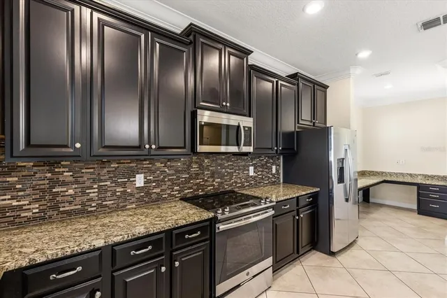 a kitchen with granite countertop stainless steel appliances and wooden cabinets