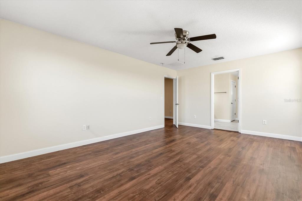 12036 Cardinal Flower Drive Riverview, FL 33579 - Photo 14 of 37 a view of empty room with wooden floor and ceiling fan