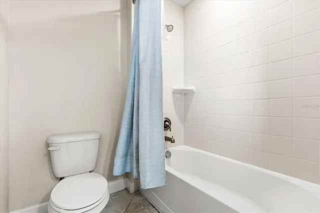 a white toilet sitting next to a bath tub