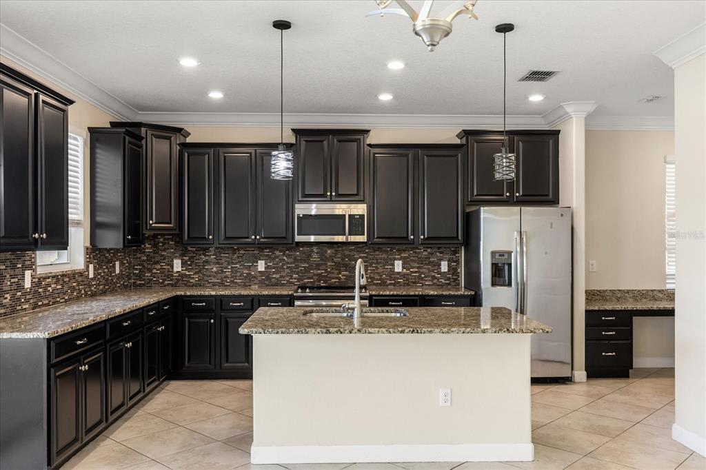 12036 Cardinal Flower Drive Riverview, FL 33579 - Photo 10 of 37 a kitchen with kitchen island a sink stainless steel appliances and cabinets