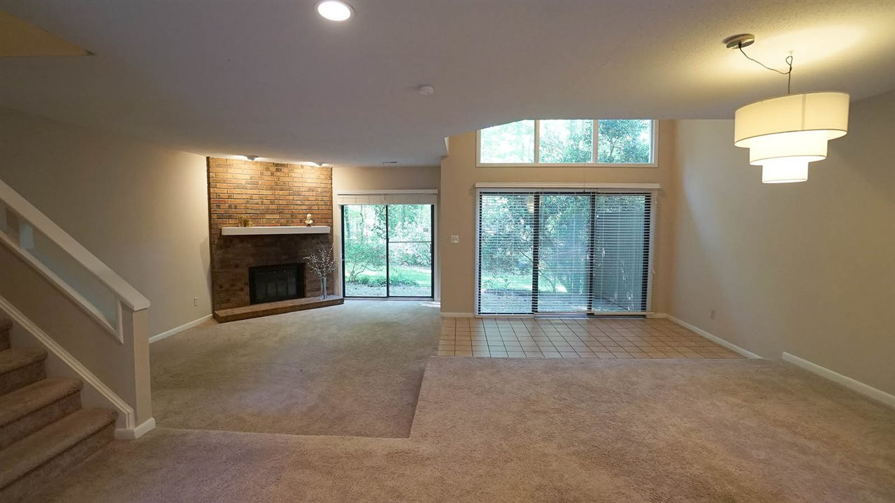 Sunken Living Room has corner Brick Fireplace with Gas Logs + Sliding Glass Doors so you can Enjoy the View of Nature at its Finest. Living Room