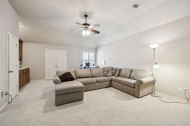 a living room with furniture and a ceiling fan