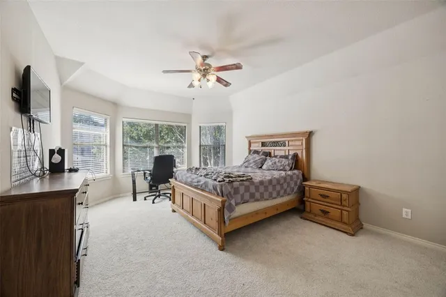 a bedroom with a bed couch tv and window