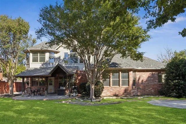 a front view of a house with garden and tree