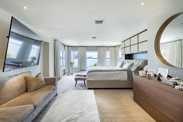 a bedroom with a large bed and a mirror