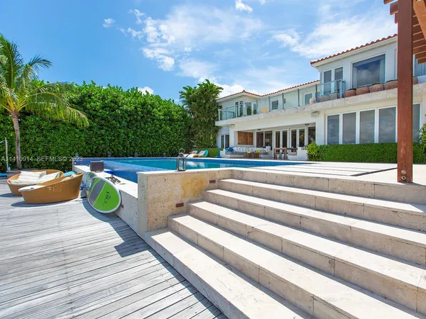 a view of a house with a swimming pool and sitting area