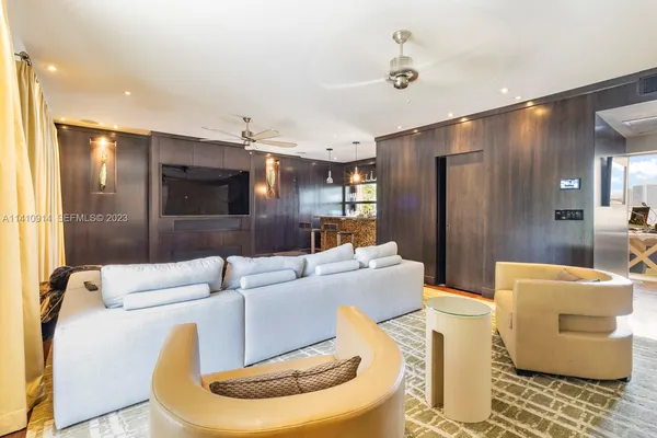a living room with furniture and a ceiling fan