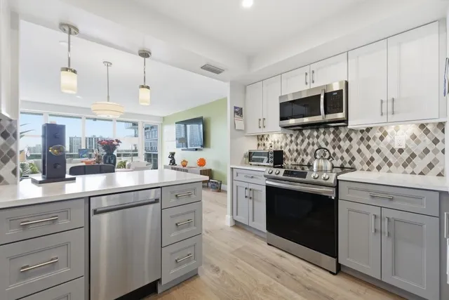 a kitchen with white cabinets and stainless steel appliances
