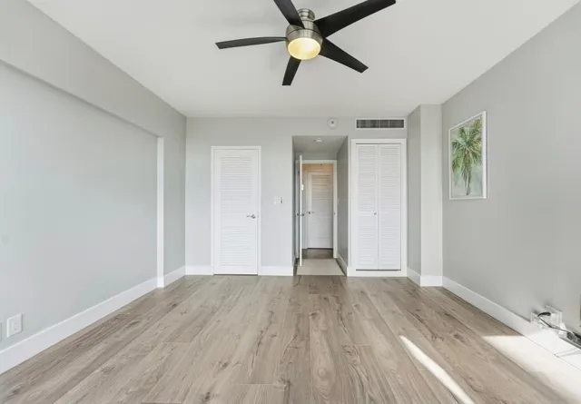 a view of empty room with wooden floor
