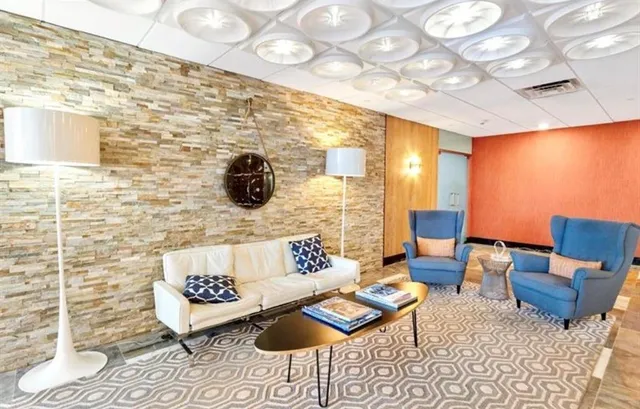 a living room with patio furniture and a rug