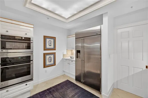 a view of a kitchen with wooden floor electronic appliances and windows