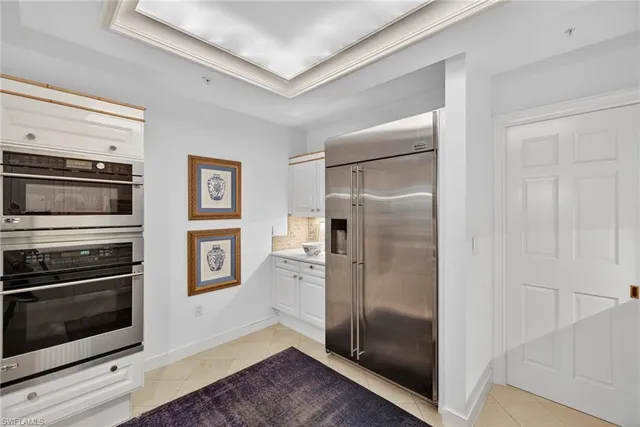 a view of a kitchen with wooden floor electronic appliances and windows