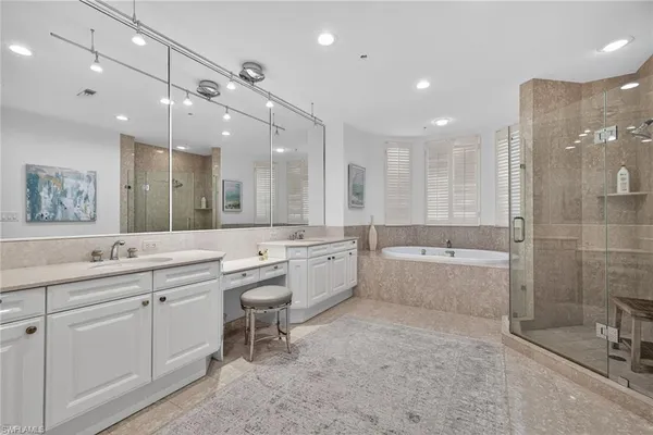 a large bathroom with a large mirror vanity and shower