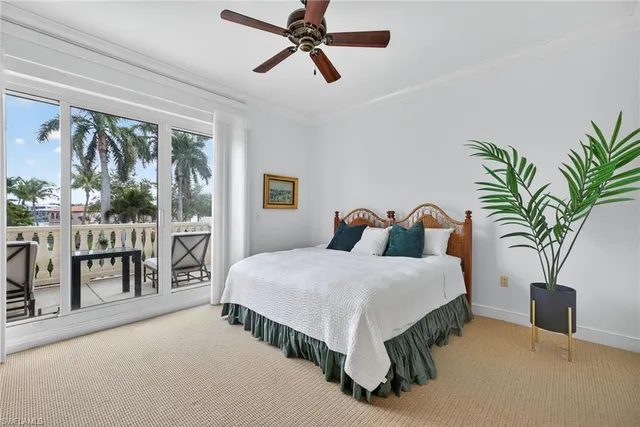 a bedroom with a large bed and a potted plant