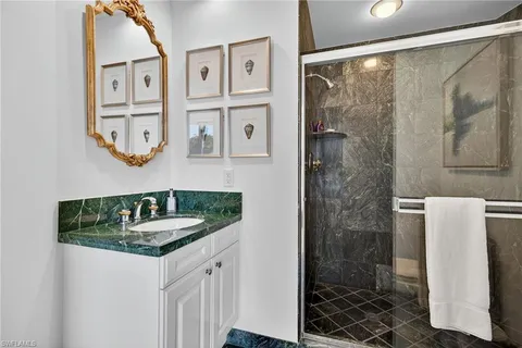 a bathroom with a granite countertop sink a mirror a shower and a bathtub
