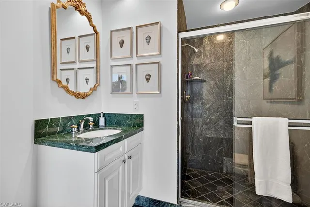 a bathroom with a granite countertop sink a mirror a shower and a bathtub