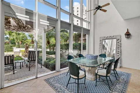 a dining room with furniture a rug and a floor to ceiling window