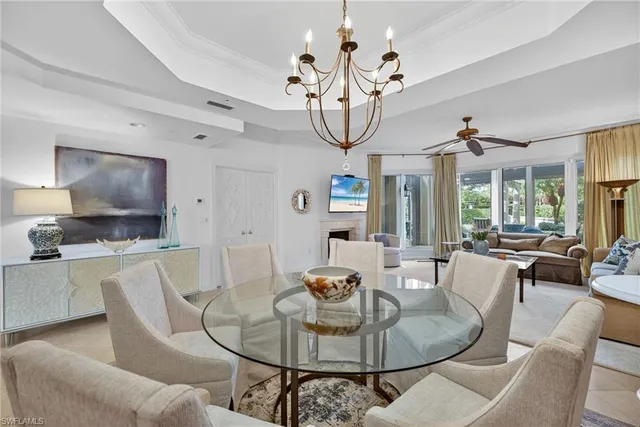 a living room with furniture a dining table and a chandelier
