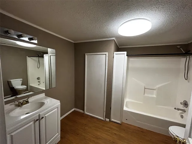 a view of a kitchen with a refrigerator and wooden floor