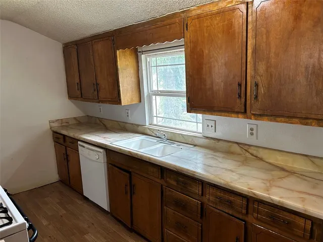 a kitchen with granite countertop cabinets sink and window