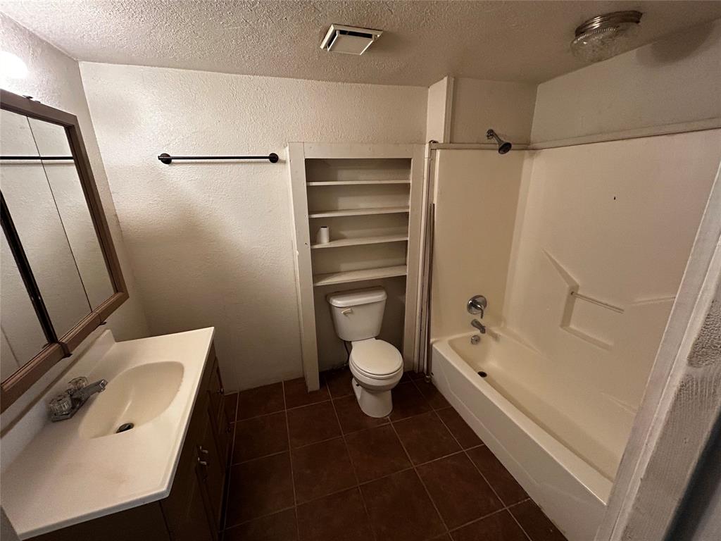 910 West Long Stephenville, TX 76401 - Photo 31 of 40 a bathroom with a granite countertop bathtub shower sink vanity and toilet