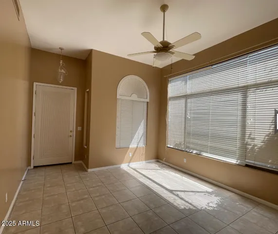 a view of a livingroom with a chandelier fan and a large window